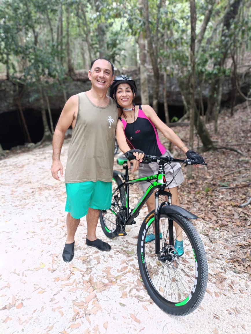 Pareja con bicicleta todo terreno junto al cenote